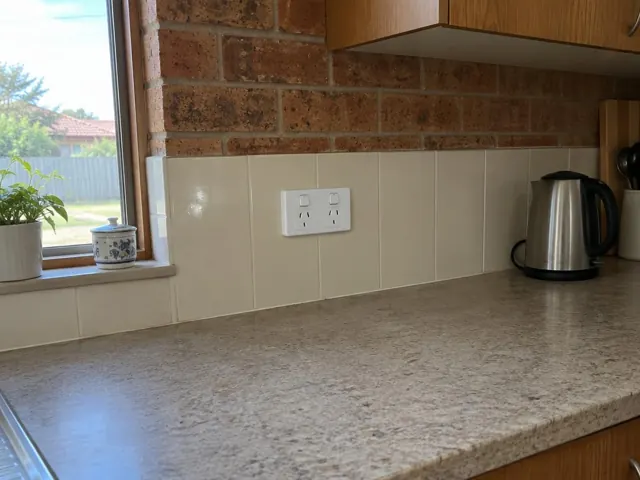 Double power point on a tiled kitchen splashback above a benchtop in Chisholm